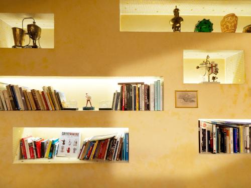 dos estanterías llenas de libros en una pared en Boutique Hotel Albero Nascosto en Trieste