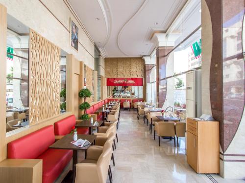 a restaurant with red chairs and tables and windows at Zahrat Al Jabal in Fès