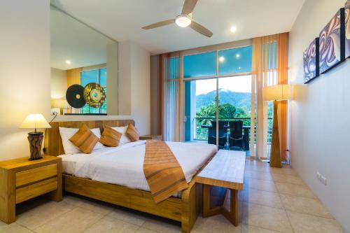 a bedroom with a bed and a large window at The Palm at Veloche Group by Lofty in Karon Beach