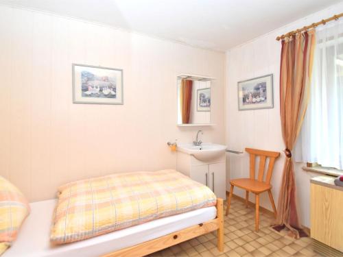 a small bedroom with a bed and a sink at Charming family friendly holiday home with backyard pool in Neukirchen