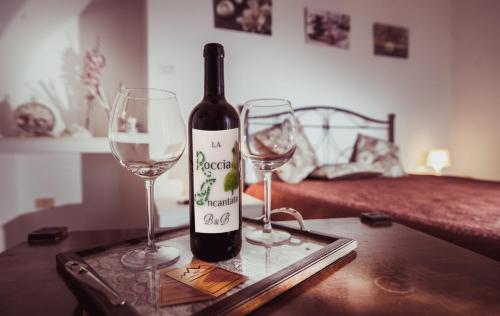 a bottle of wine and two wine glasses on a table at La Roccia Incantata Amalfi Coast in Vietri sul Mare