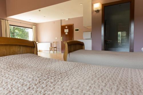 a hotel room with two beds and a kitchen at Estudios Ermitabarri in Zeberio