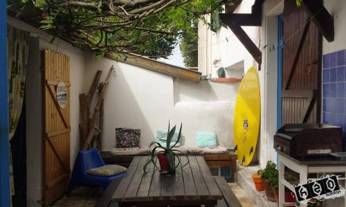 een patio met een houten tafel en een surfplank bij h2oholidays - auberge de jeunesse - youth hostel in Capbreton