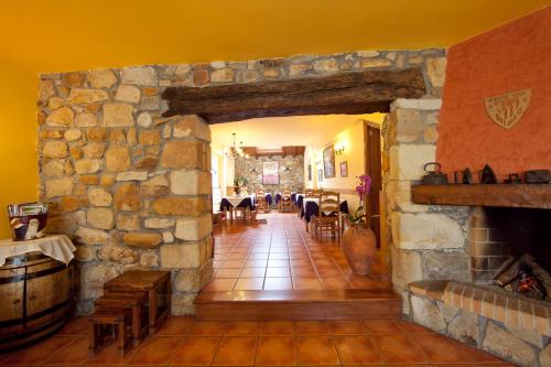 a living room with a stone wall and a fireplace at Hotel Rural Matsa in Lezama