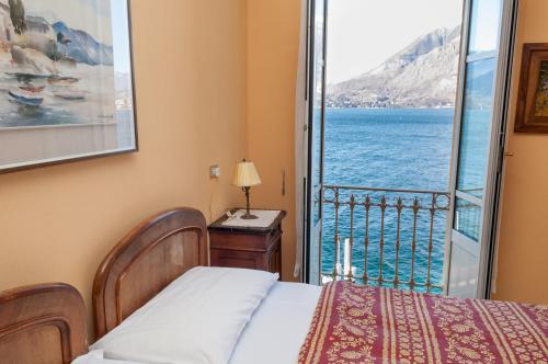 a bedroom with a bed and a view of the ocean at Hotel Olivedo in Varenna
