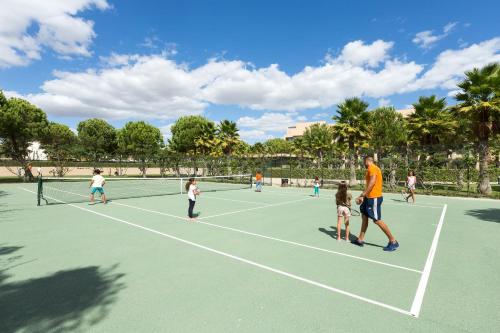 a group of people playing tennis on a tennis court at NAU Sao Rafael Suites - All Inclusive in Albufeira