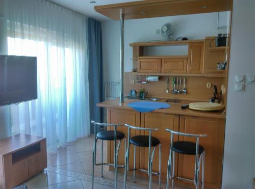 uma cozinha com um balcão e bancos num quarto em ApartamentyPrzyMorzu Reymonta em Kolobrzeg