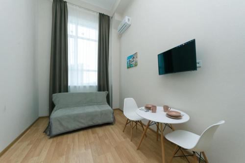 ein Wohnzimmer mit einem Tisch und einem Stuhl in der Unterkunft Dvukhurovnevyi liuks na Beresteiskoi in Kiew