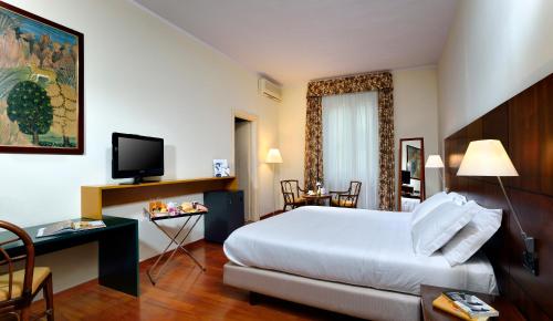 a hotel room with a bed and a desk and a television at Best Western Hotel Crimea in Turin