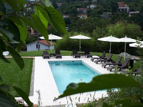 una piscina con tumbonas y sombrillas en Guest House Stancija Kovacici, en Opatija