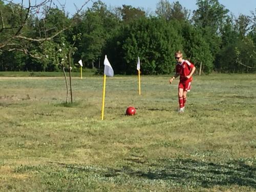 a man in a field with a soccer ball at Lavender Village in Kiemeliai
