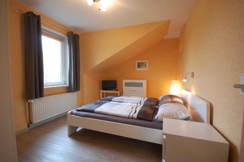 ein Schlafzimmer mit einem großen Bett in einem Zimmer in der Unterkunft Ferienwohnung Pohnsdorfer Mühle in Sierksdorf