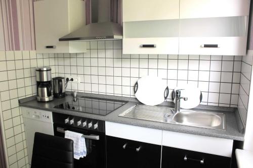 a small kitchen with a sink and a stove at Ferienwohnung Pohnsdorfer Muehle in Sierksdorf