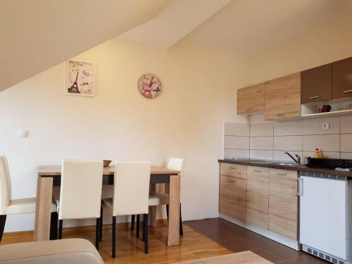 a kitchen with a wooden table and white chairs at Apartment Nina in Zlatibor