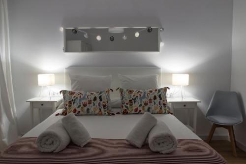 una camera da letto con letto, cuscini e specchio di El rincón de Orive a Cordoba