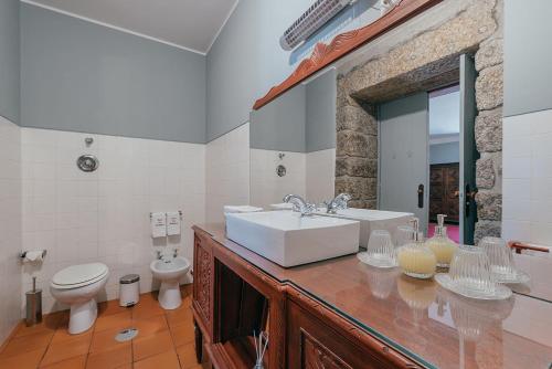 a bathroom with a sink and a toilet at Casa Dos Pombais in Guimarães