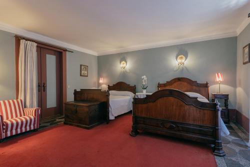 a bedroom with two beds and a red carpet at Casa Dos Pombais in Guimarães