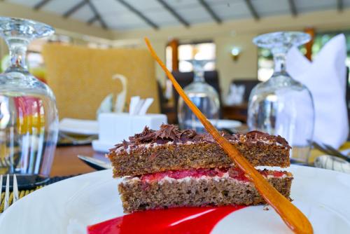 a piece of cake on a plate on a table at Sagana Getaway Resort in Maranjua