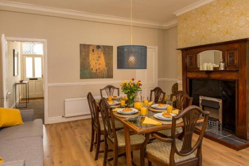 een eetkamer met een tafel en een open haard bij Marsden Lodge in Nelson