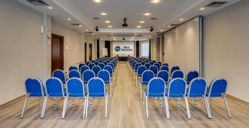 a conference room with blue chairs and a screen at Best Western Hotel Turismo in San Martino Buon Albergo