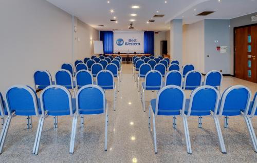 a room with blue chairs in a room with a screen at Best Western Hotel Turismo in San Martino Buon Albergo