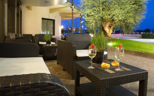 a restaurant with a table with glasses of wine at Best Western Hotel Turismo in San Martino Buon Albergo