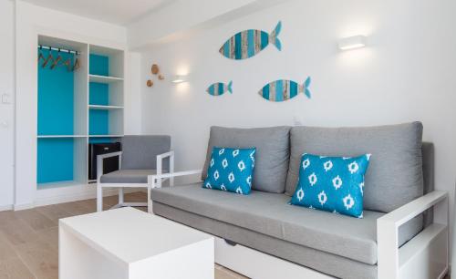 a living room with a couch and a chair at BLUESEA Gran Playa in Sa Coma