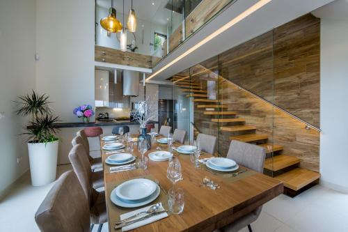 a dining room with a table and chairs and a staircase at Villa AltaVista - Seaview & Relax with Heated Pool & MiniGolf in Opatija