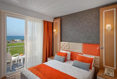 a bedroom with a bed and a large window at Golden Orange Hotel in Antalya