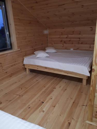 a bedroom with a bed in a wooden cabin at Шале Озера in Melʼniki