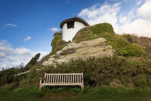 a wooden bench sitting on top of a rock at Gara Rock in Salcombe