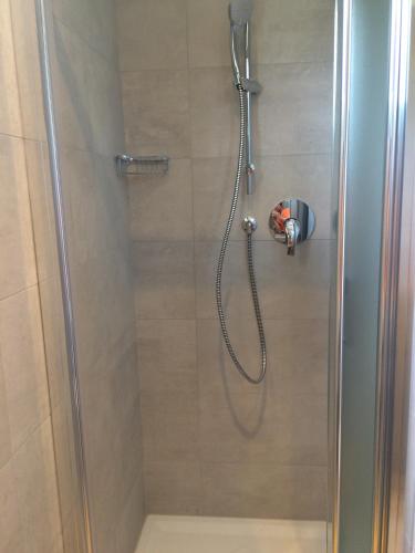 a shower with a glass door with a shower head at Hotel Pigalle in Riccione