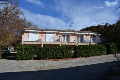 un bâtiment avec des buissons devant lui dans l'établissement Résidence de l'Escoulaou, à Castellane