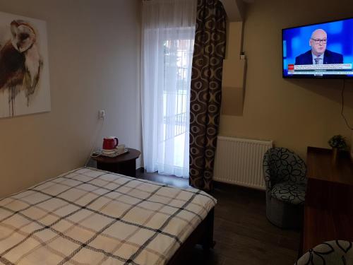 a bedroom with a bed and a flat screen tv at Marcus in Bydgoszcz