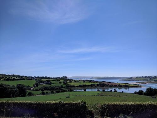 - une vue sur une rivière depuis une colline avec un champ dans l'établissement Seafield Farmhouse, à Kilbrittain