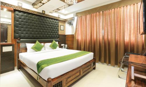 a bedroom with a large bed and a desk at Hotel Dvaraka Inn in Bengaluru