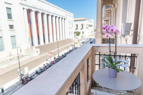 a balcony with a table and flowers on a building at Sweet Roma 315 in Palermo