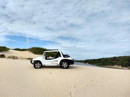 a white car parked on the sand on a beach at Pousada Familiar Beberibe in Beberibe