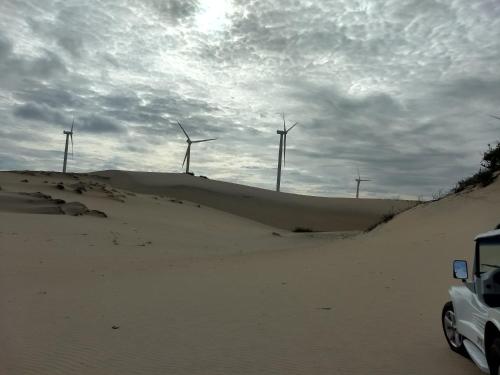a desert with wind turbines on top of a sand hill at Pousada Familiar Beberibe in Beberibe