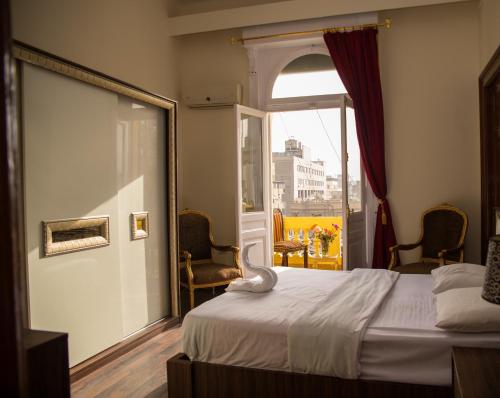 um quarto de hotel com uma cama e uma janela em New Grand Royal Hotel Cairo no Cairo
