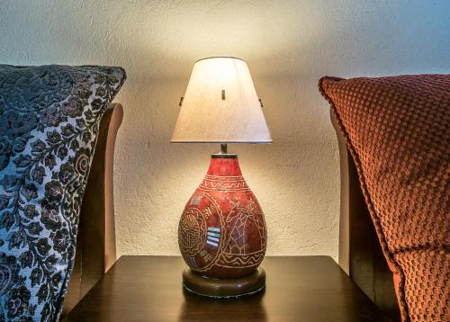 a red lamp sitting on a table next to a bed at Karen Gables in Nairobi