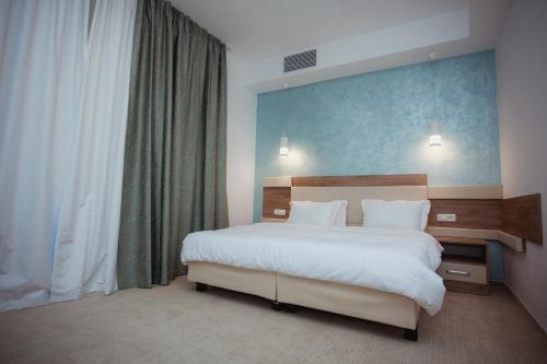 a bedroom with a large bed and a large window at Tci Social Club in Cluj-Napoca