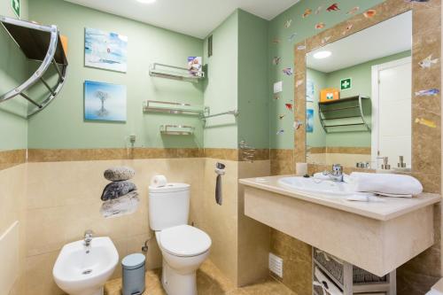 y baño con aseo, lavabo y espejo. en Tropical Beach Apartment Litoralmar, en Portimão