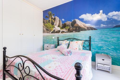 - une chambre avec un lit orné d'une peinture sur l'océan dans l'établissement Tropical Beach Apartment Litoralmar, à Portimão