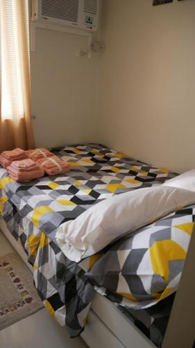 a bedroom with a bed with a checkered blanket at Genesis unit SMDC Fields in Manila