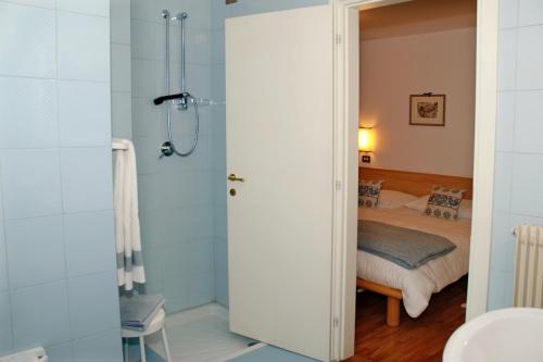 a bathroom with a shower and a bed at Albergo Centrale in Santo Stefano di Cadore