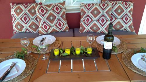 a table with a bottle of wine and glasses on it at Olive garden guest house in Kyparissia