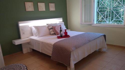 a bedroom with a bed in a green wall at Olive garden guest house in Kyparissia