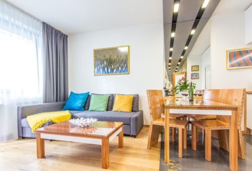 uma sala de estar com um sofá e uma mesa em Apartamenty Granitica Zakopane em Zakopane