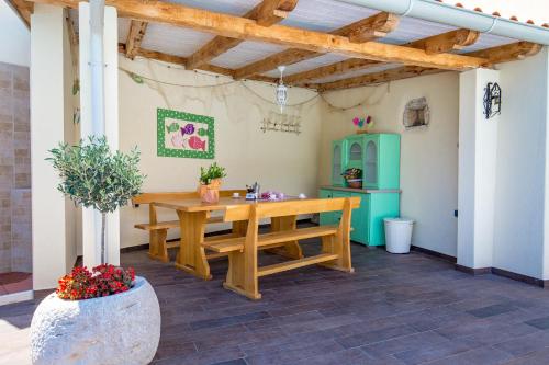a patio with a wooden table and a green refrigerator at Villa Chiara in Brseč